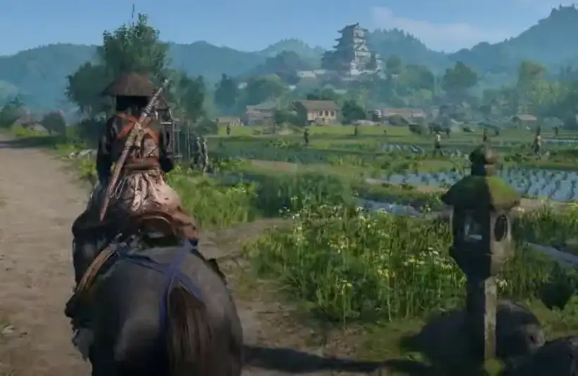Assassin's Creed Shadows samurai rides on a horse down a rural path, surrounded by lush fields and distant mountains.