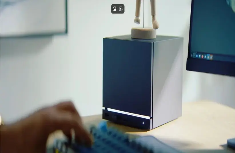 The Steam Machine, created by Valve, sitting by a computer.